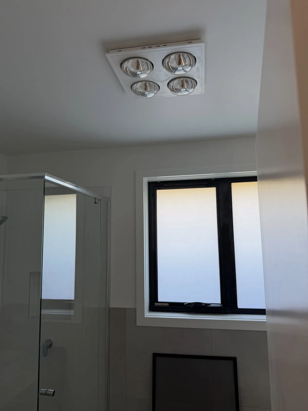 Bathroom window with a frosted pane and a ceiling heater